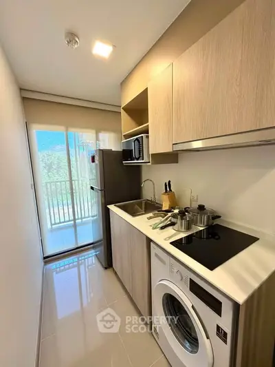 Modern kitchen with sleek appliances and balcony view in a stylish apartment.