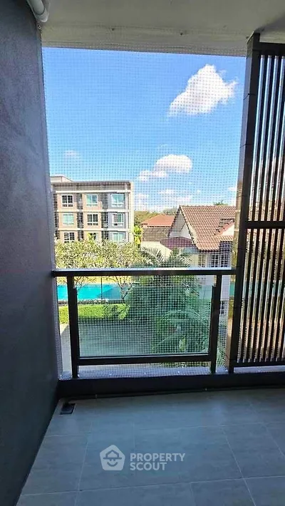 Charming balcony with serene view of residential area and blue sky.