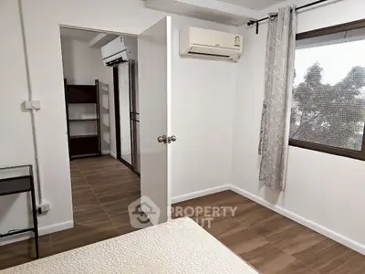 Modern bedroom with air conditioning and large window for natural light.