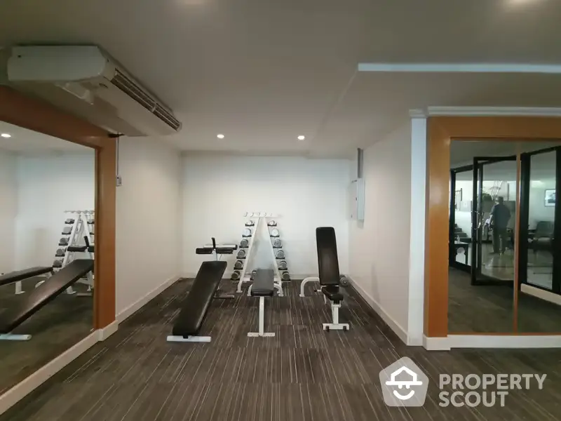 Modern fitness center within residential property boasting state-of-the-art exercise equipment, sleek design, and a welcoming atmosphere for an active lifestyle.