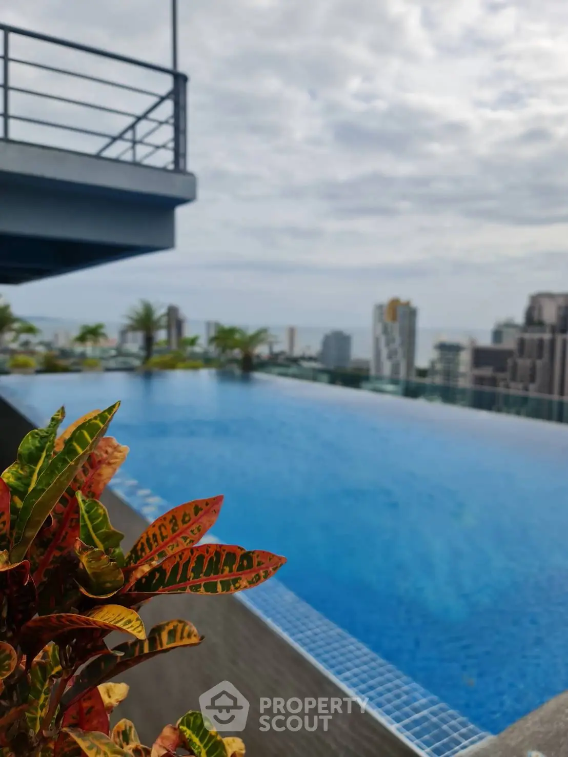 Luxurious rooftop infinity pool with stunning city skyline views and lush greenery.