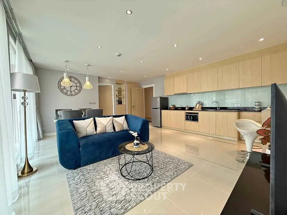 Modern open-plan living room with stylish kitchen and cozy blue sofa