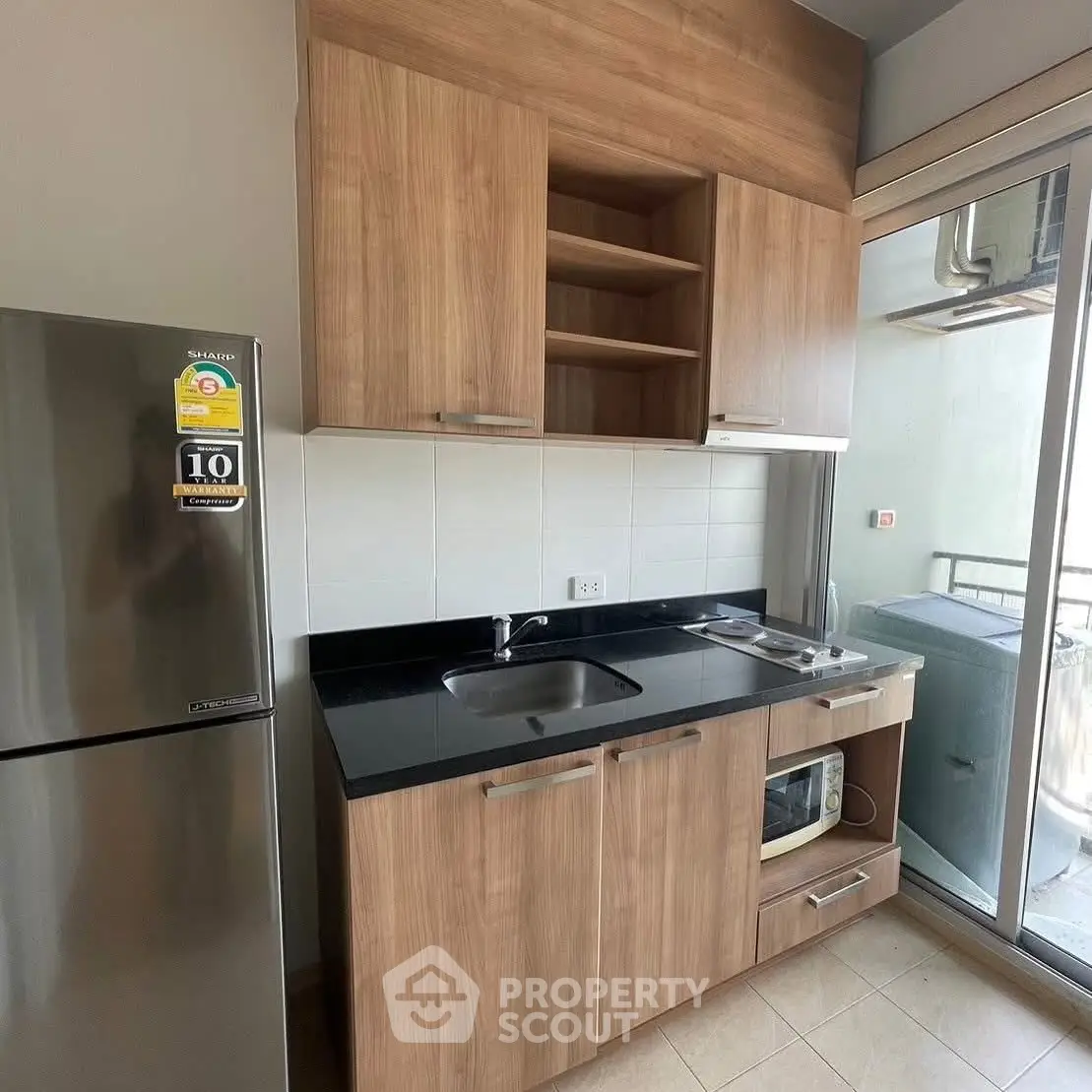 Modern kitchen with wooden cabinets and stainless steel appliances in a compact layout.
