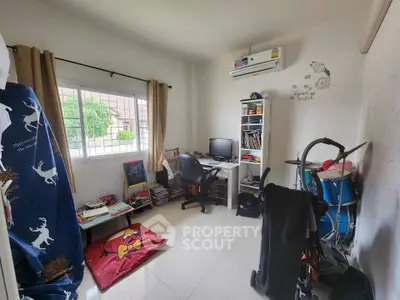 Cozy study room with desk, computer, and drum set, perfect for work and play.