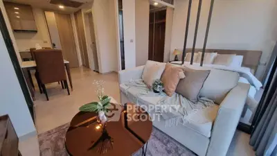 Modern open-plan living room with cozy sofa and elegant dining area in stylish apartment.