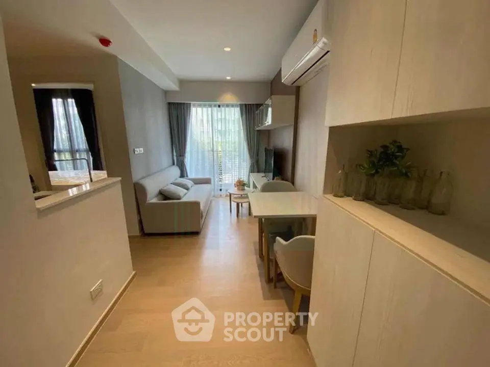 Modern living room with open layout and stylish decor, featuring a cozy sofa and dining area.