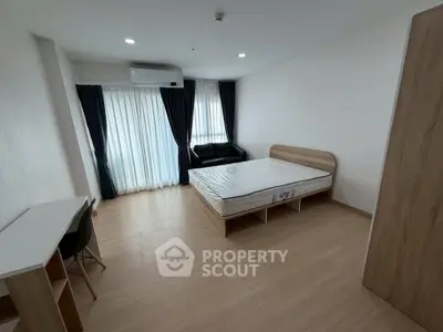 Spacious bedroom with modern furnishings and natural light in a stylish apartment.