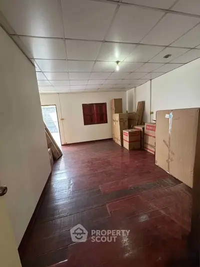 Spacious storage room with wooden flooring and ample natural light.