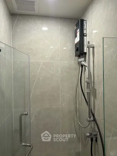 Modern bathroom with sleek shower and glass enclosure, featuring elegant tile design.