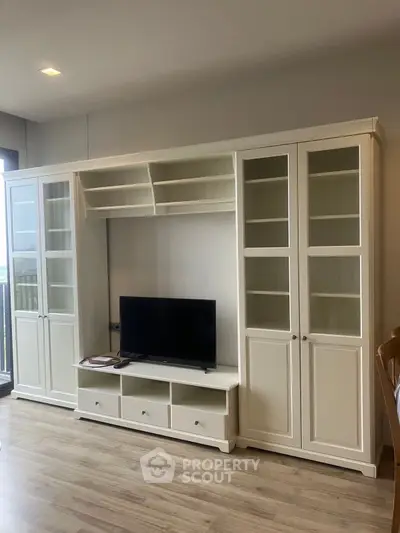 Spacious living room with elegant white cabinetry and modern TV setup
