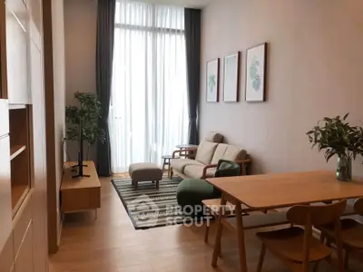 Stylish modern living room with high ceilings, elegant furniture, and natural light.
