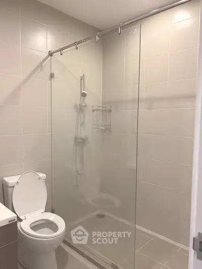 Modern bathroom with glass shower enclosure and sleek tile design.