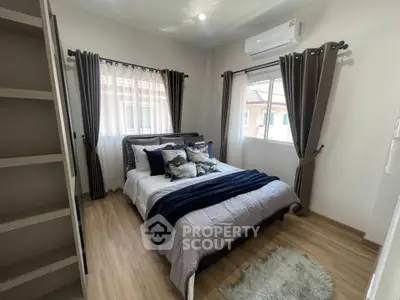 Cozy bedroom with modern decor and ample natural light, featuring a comfortable bed and stylish curtains.