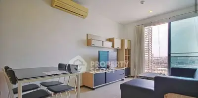 Modern living room with sleek furniture and city view balcony in high-rise apartment.
