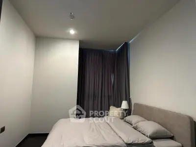 Cozy modern bedroom with soft lighting and elegant curtains, perfect for relaxation.