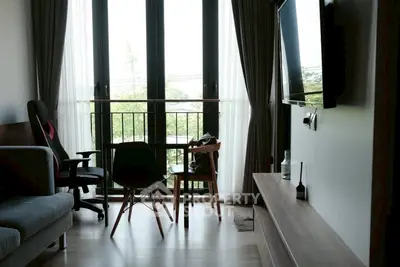 Modern living room with large windows and stylish furniture, offering a bright and inviting atmosphere.