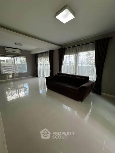 Spacious living room with modern sofa and large windows for natural light.