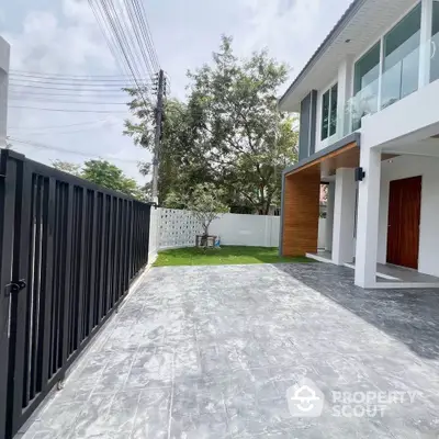 Modern two-story house with spacious driveway and lush garden