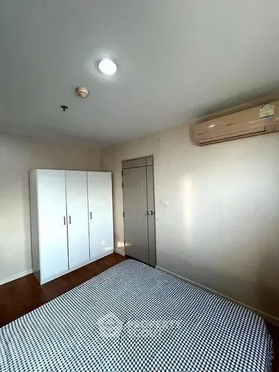 Cozy bedroom with air conditioning and wardrobe in modern apartment
