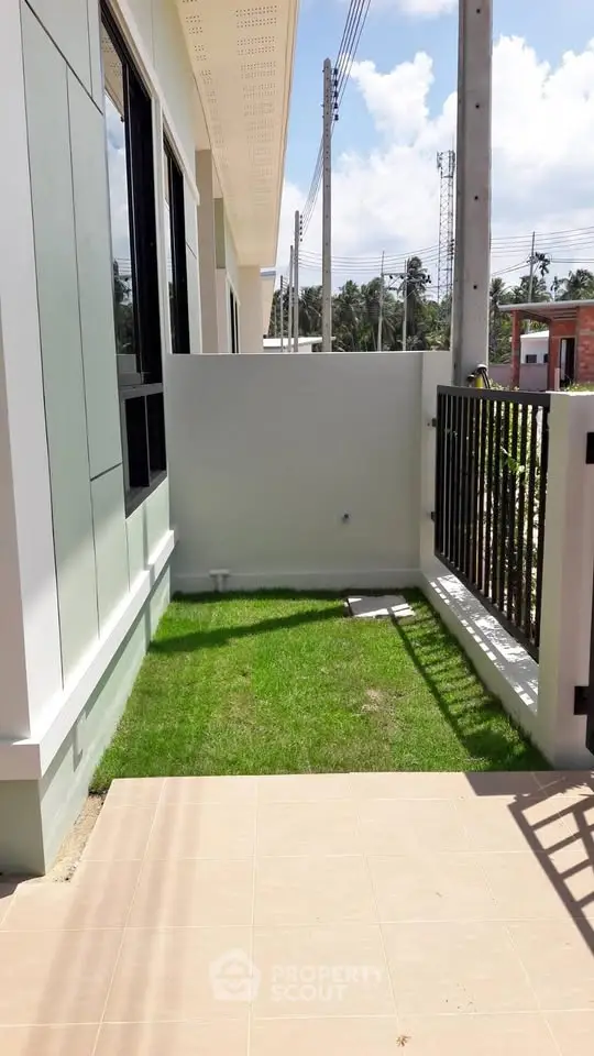 Charming small garden area in modern townhouse exterior with sunny ambiance.