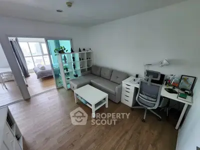 Modern living room with cozy sofa, study desk, and open view to bedroom, perfect for urban living.