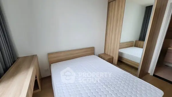 Modern bedroom with wooden furniture and large mirror wardrobe