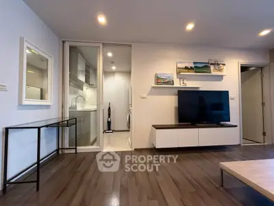 Modern living room with sleek design and open kitchen layout, featuring hardwood floors and stylish decor.