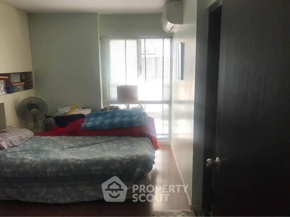 Cozy bedroom with natural light and air conditioning, perfect for relaxation.
