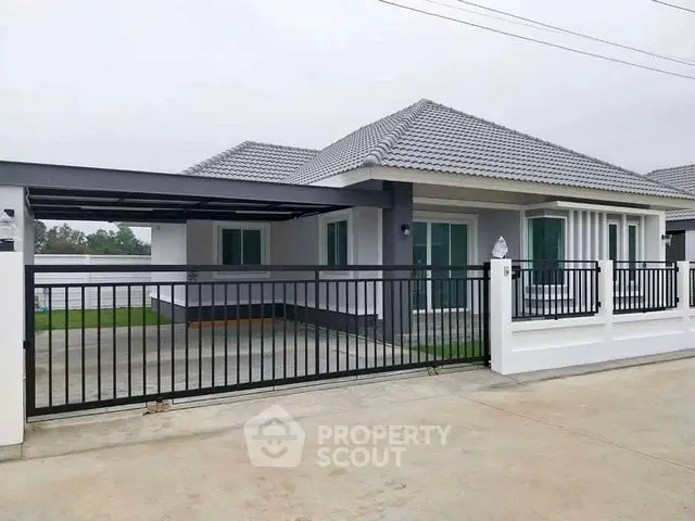 Modern single-story house with gated driveway and sleek exterior design.