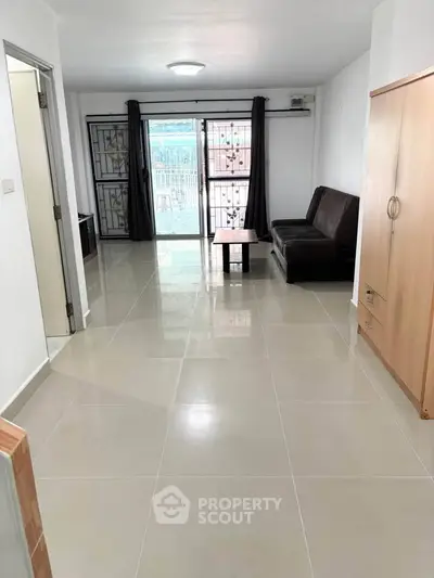 Spacious living room with modern sofa and large windows for natural light.