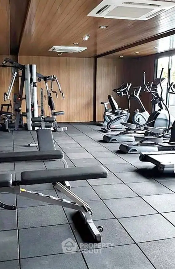 Modern gym with state-of-the-art fitness equipment in a sleek wooden interior.