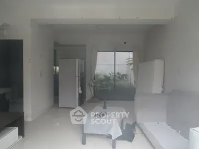 Spacious living room with sliding glass doors and garden view, featuring modern furniture and natural light.