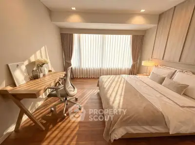 Elegant bedroom with natural light, wooden flooring, and modern furnishings, perfect for a cozy retreat.