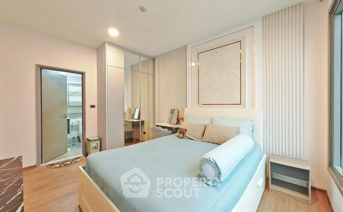 Modern bedroom with stylish decor and large window offering natural light