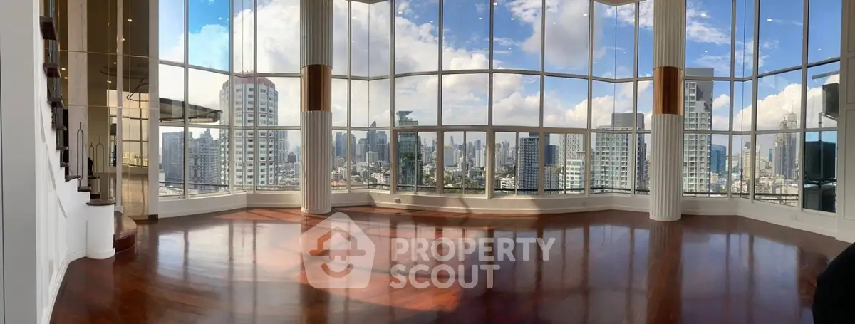 Stunning panoramic city view from a luxurious high-rise living room with floor-to-ceiling windows.