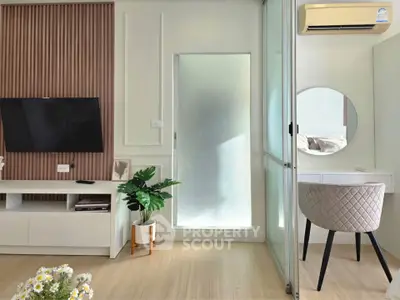 Modern living room with stylish decor, TV, and elegant furniture in a bright, airy space.