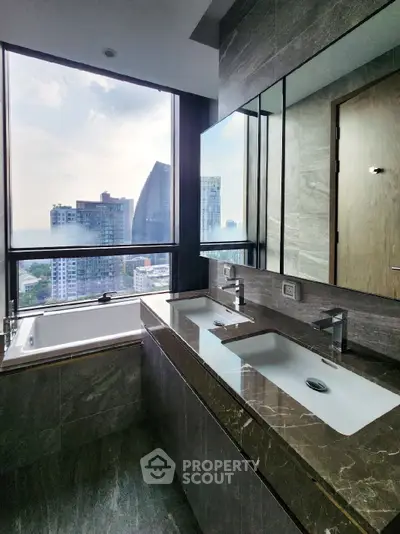 Luxurious bathroom with dual sinks and city view in high-rise apartment