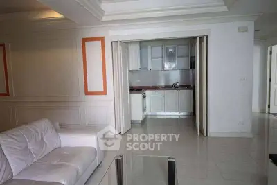 Spacious living room with open kitchen layout and modern furnishings.