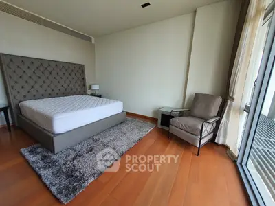 Spacious bedroom with modern decor and large windows for natural light