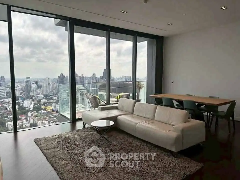 Luxurious living room with stunning city view and modern furniture in high-rise apartment.
