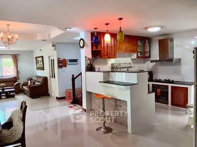 Spacious open-plan living room and kitchen with modern decor and bright lighting.