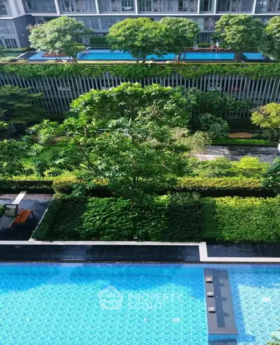 Luxurious condominium with lush gardens and sparkling swimming pool, offering serene urban living.