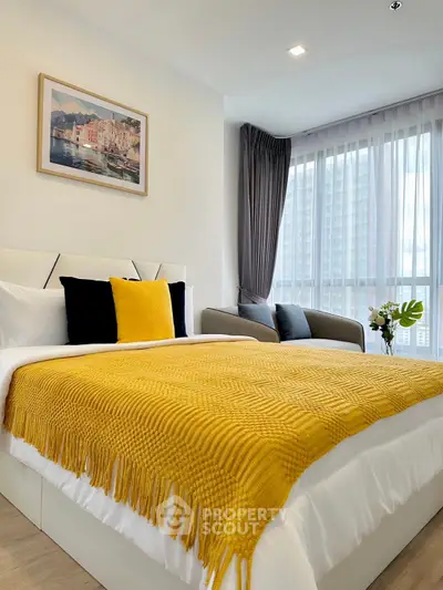 Bright and cozy bedroom with modern decor and large window view.