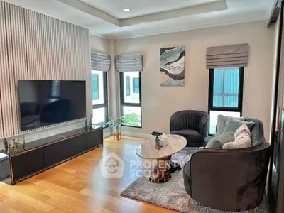 Modern living room with stylish decor, large TV, and cozy seating area.