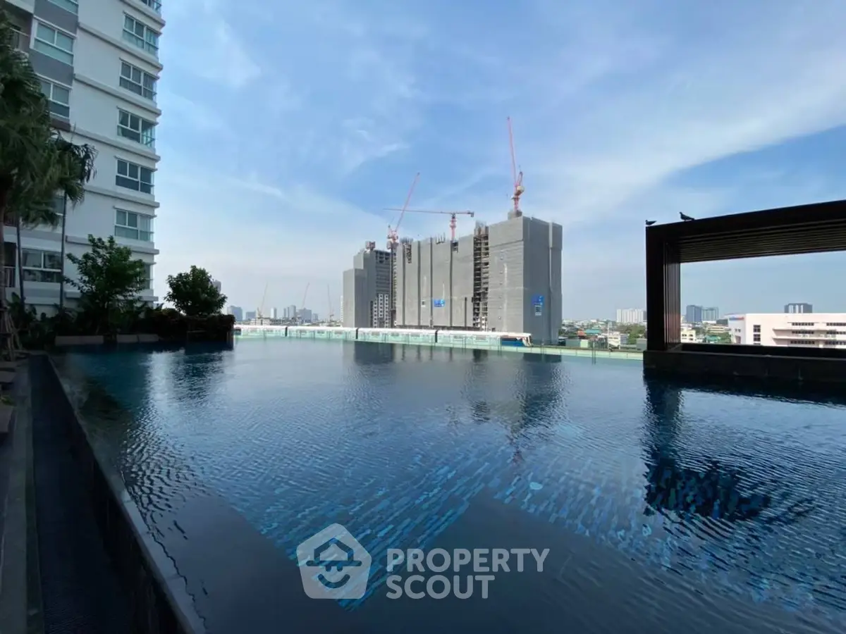Luxurious rooftop pool with stunning city skyline view in modern apartment complex.