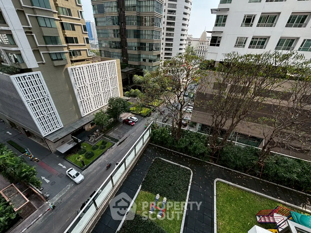 Stunning urban view from a high-rise building showcasing modern architecture and lush greenery.