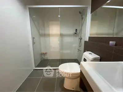 Modern bathroom with glass shower enclosure and sleek fixtures