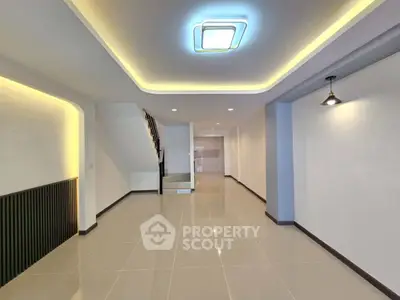 Spacious modern living area with sleek tile flooring and ambient lighting