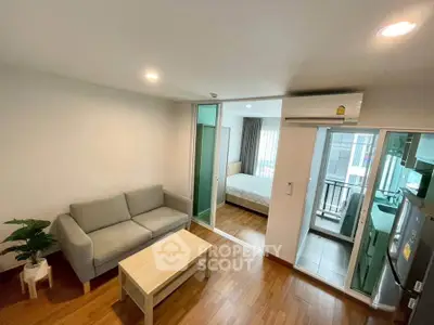 Modern apartment interior with cozy living room and bedroom, featuring wooden flooring and natural light.