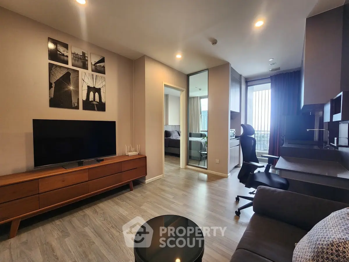 Modern living room with sleek furniture and open layout, featuring a cozy bedroom view.